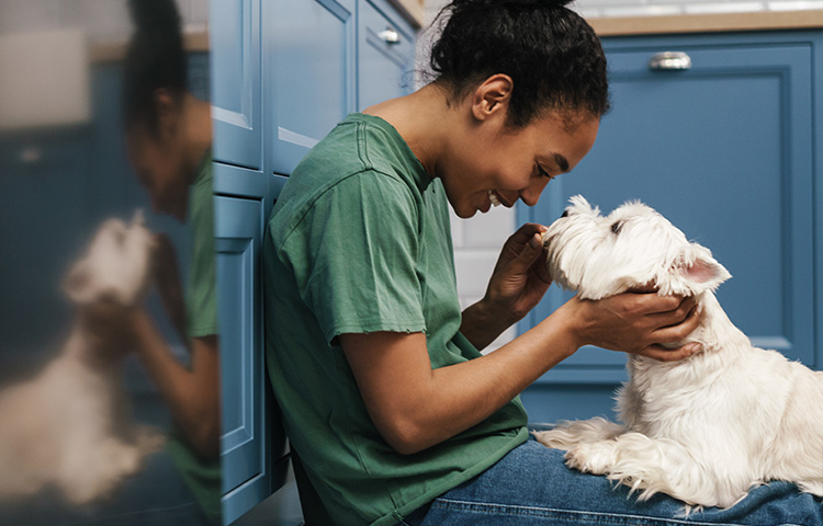 girl-sitting-down-holding-a-white-puppy